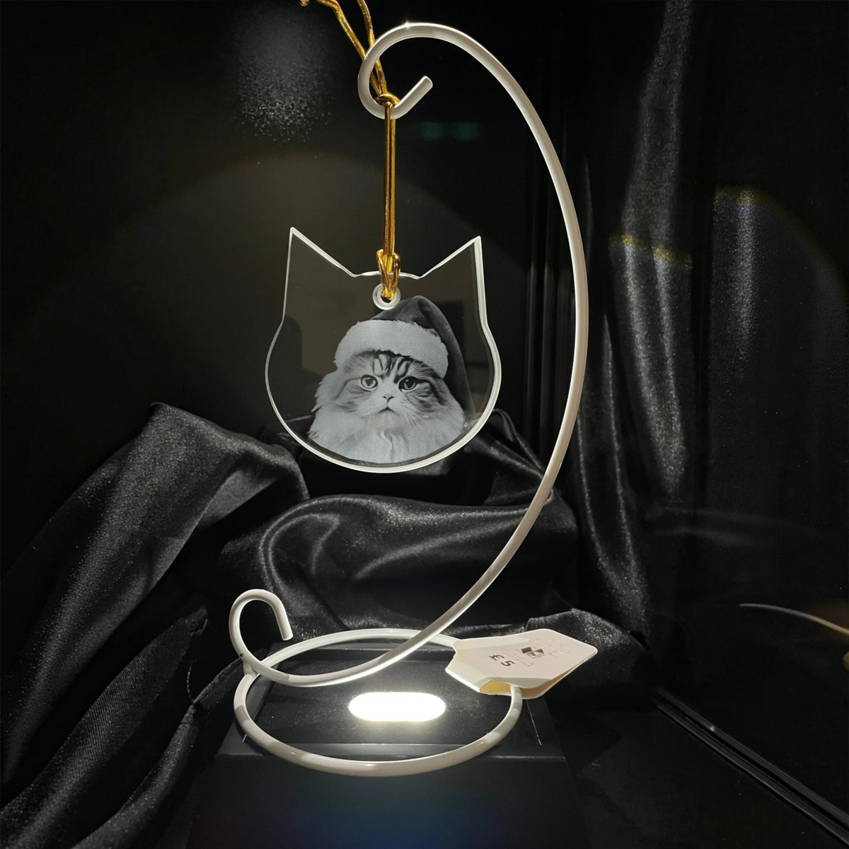 Sarnia3Dcrystals custom engraved cat shaped acrylic ornament with a Santa hat portrait hanging on a white stand.