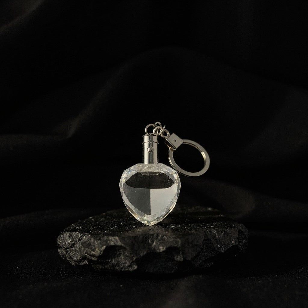 Sarnia3Dcrystals heart-shaped optical crystal keychain with silver hardware displayed on a textured black stone base.