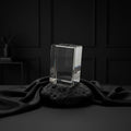 Sarnia3Dcrystals medium rectangular optical crystal block displayed on a black volcanic rock against a dark background.